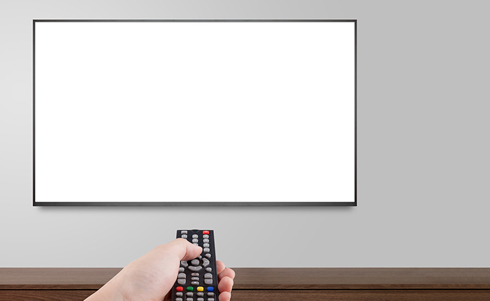 A remote being pointed at a blank white tv screen