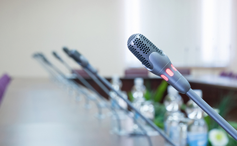 Pictures of empty microphones in a line for a speaking panel