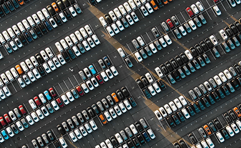 Overhead view of a crowded auto dealership parking lot full of vehicles
