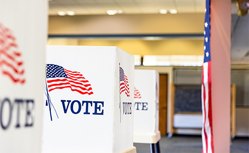 Voting booths adorn with American flags and the word vote