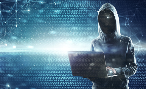 Hooded individual holding a laptop over a high tech background