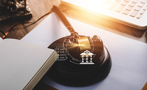 A judge's gavel on a desk with judicial logos overtop