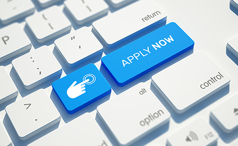 Blue apply now button on a computer keyboard