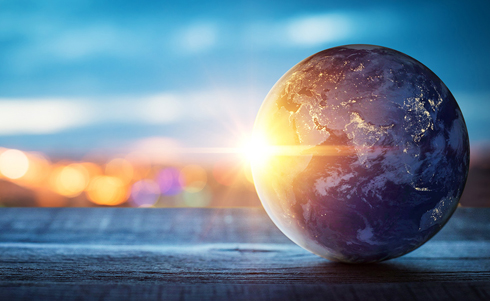 The globe with a sun beam shining behind it