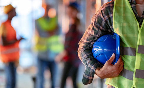 Construction worker carrying a blue safety helmet