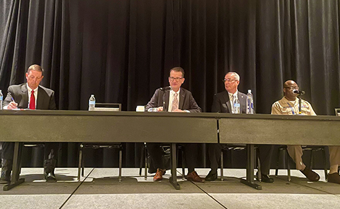 Individuals sitting on a speaking panel