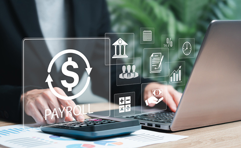 Payroll symbols overtop a man using a laptop