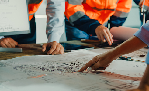 Business people and construction workers reviewing drawings on a table