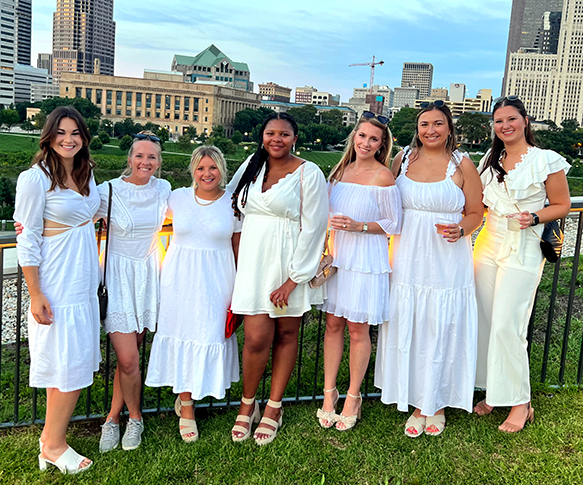 A group of women wearing white outside at the Women's Collaborative event