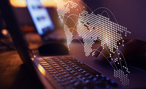 Laptop with a world map on top symbolizing global data