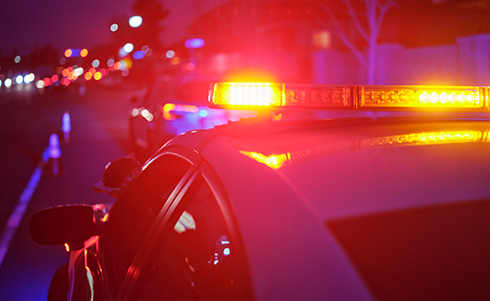 Police lights flashing during a traffic stop at night