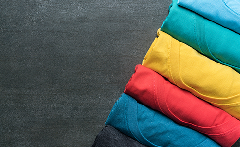 Multicolored t shirts folded cylindrically and placed in a line