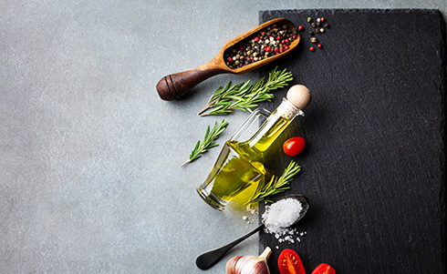 Various whole spices, oil, and tomatoes